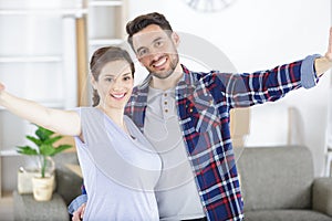 happy pregnant couple with belongings at new home