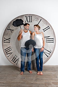 Happy Pregnant Couple dressed in white showing sign speech bubble banners