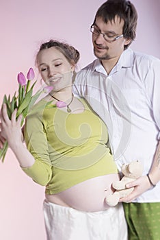 Happy pregnant couple with tulips