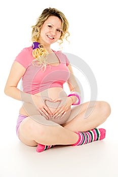 Happy a pregnant girl sitting hugging belly
