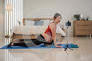 Happy pregnant mother practicing exercises for her healthcare and her unborn baby