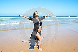 Happy pregnant woman on the beach