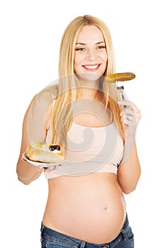 Happy pregnant woman with cake and pickles