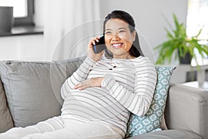 happy pregnant woman calling on smartphone at home