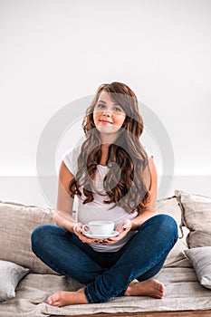 Happy pregnant woman with cup of tea.