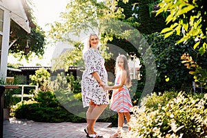 Happy pregnant woman with daughter in garden