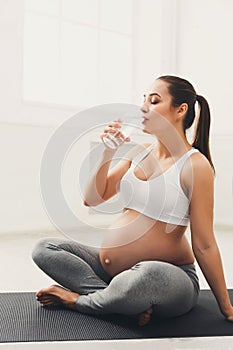 Happy pregnant woman drinking water