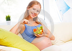 Happy pregnant woman eats healthy food vegetable salad