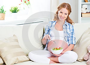 Happy pregnant woman eats healthy food vegetable salad