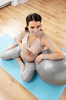 Happy pregnant woman with fitball at home