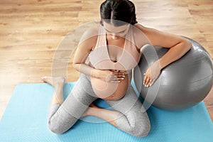 Happy pregnant woman with fitball at home