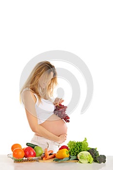 Happy pregnant woman with fruits and vegetables