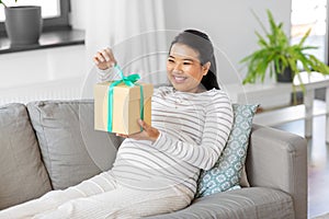 happy pregnant woman with gift box at home