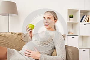 Happy pregnant woman with green apple