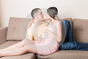 Happy pregnant woman and her husband waiting for baby at the home. happy family love and care concept