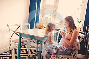 Happy pregnant woman with her toddler daughter playing at home