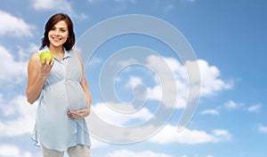 Happy pregnant woman holding green apple