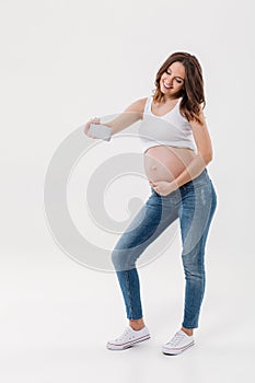 Happy pregnant woman make selfie with her belly