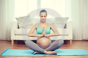 Happy pregnant woman meditating at home