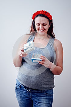 Happy pregnant woman opening gift