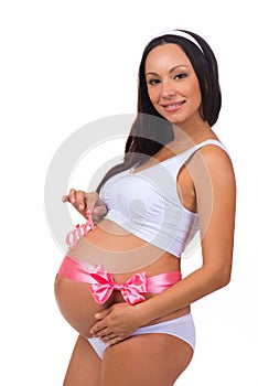 Happy pregnant woman with pink ribbon bow. Gender of a child - newborn baby girl