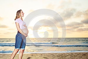 Happy pregnant woman pose over sunset ocean beach