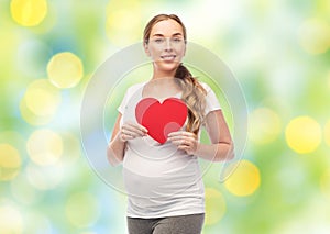 Happy pregnant woman with red heart