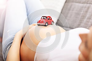 Happy pregnant woman resting on sofa