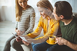 Happy pregnant woman showing photo of her unborn child