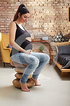 Happy pregnant woman sitting at home