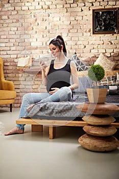 Happy pregnant woman sitting at home