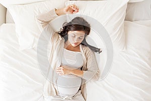 Happy pregnant woman sleeping in bed at home