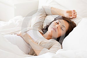 Happy pregnant woman sleeping in bed at home