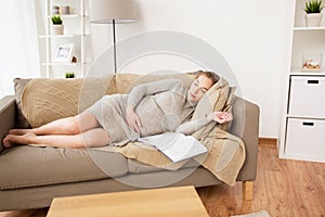 Happy pregnant woman sleeping on sofa at home