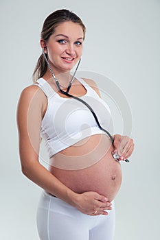 Happy pregnant woman with stethoscope