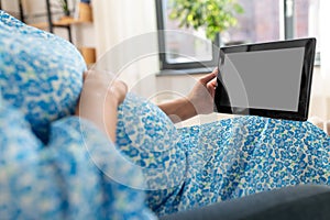 happy pregnant woman with tablet computer at home