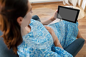 happy pregnant woman with tablet computer at home