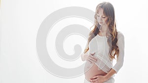 Happy pregnant woman touching her beautiful belly. Pregnancy, motherhood, and expectation