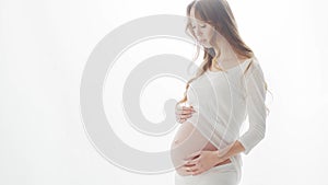 Happy pregnant woman touching her beautiful belly. Pregnancy, motherhood, and expectation