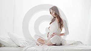 Happy pregnant woman touching her beautiful belly. Pregnancy, motherhood, and expectation concept