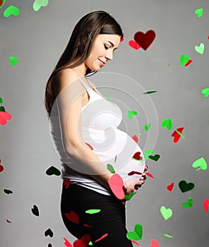 Happy pregnant woman touching her belly