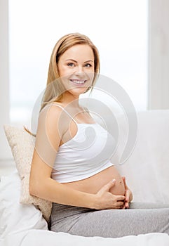 Happy pregnant woman touching her belly