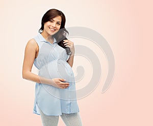 Happy pregnant woman touching her big belly