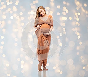 Happy pregnant woman touching her big belly