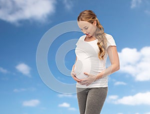 Happy pregnant woman touching her big belly