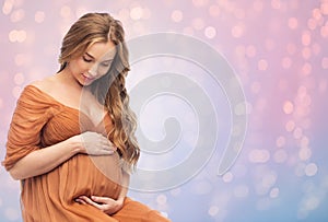 Happy pregnant woman touching her big belly