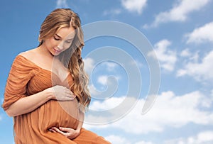 Happy pregnant woman touching her big belly