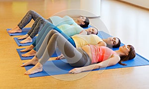 Happy pregnant women exercising on mats in gym