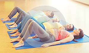 Happy pregnant women exercising on mats in gym