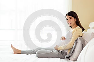 Happy pregnant young asian woman touching belly, love her baby or fetus with happiness smile face, look at camera. Pregnancy girl